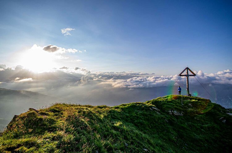 Wanderer beim Gipfelkreuz im Wipptal