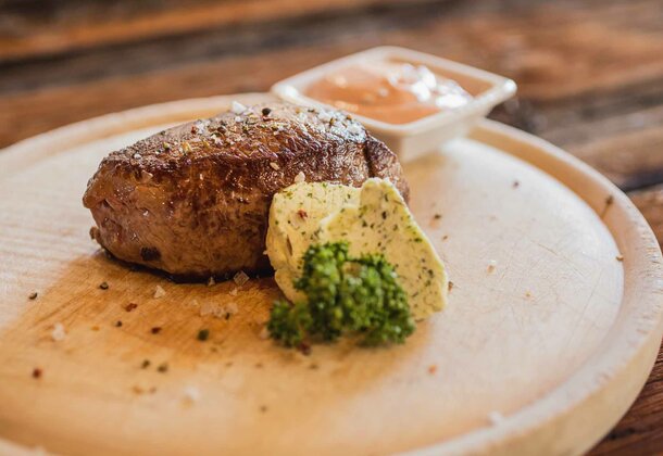 Steak auf Holzbrett angerichtet im Hotel Hohe Burg in Trins